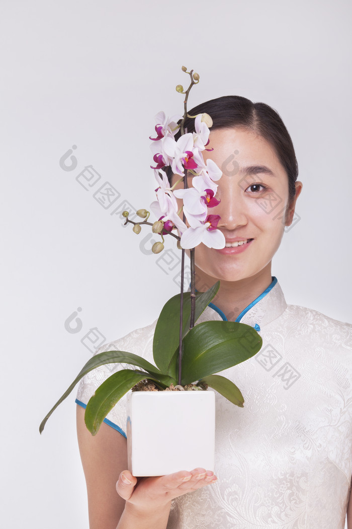 拿花朵盆栽挡脸的女人