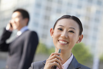 男人女人穿西装的工作户外拿着手机商业微笑