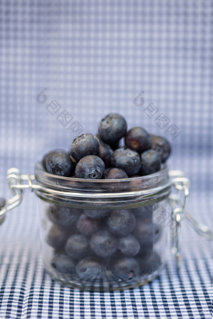 蓝色调一瓶美味蓝莓摄影图