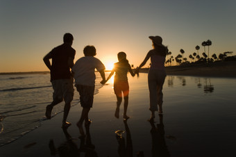 暗色调在海边奔跑的家人摄影图
