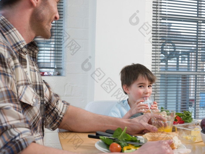 深色调在吃饭的父子摄影图