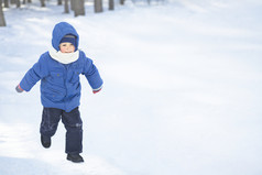 穿蓝色棉服的小男孩雪地奔跑