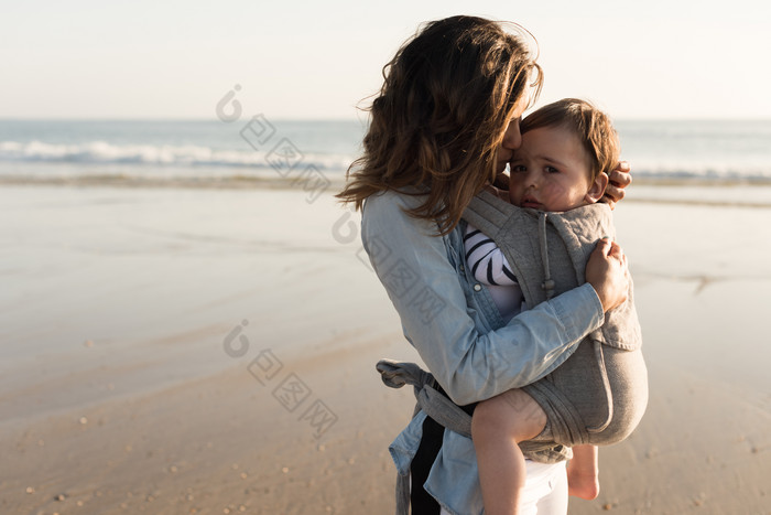 在海边和妈妈一起晒太阳的婴儿
