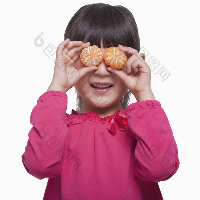 小女孩儿童拿着两个橘子遮住眼睛调皮的摄影