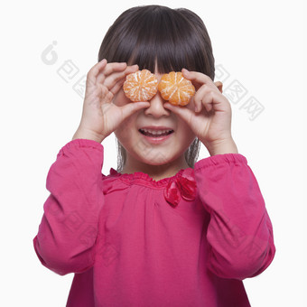 小女孩儿童拿着两个橘子遮住眼睛调皮的摄影