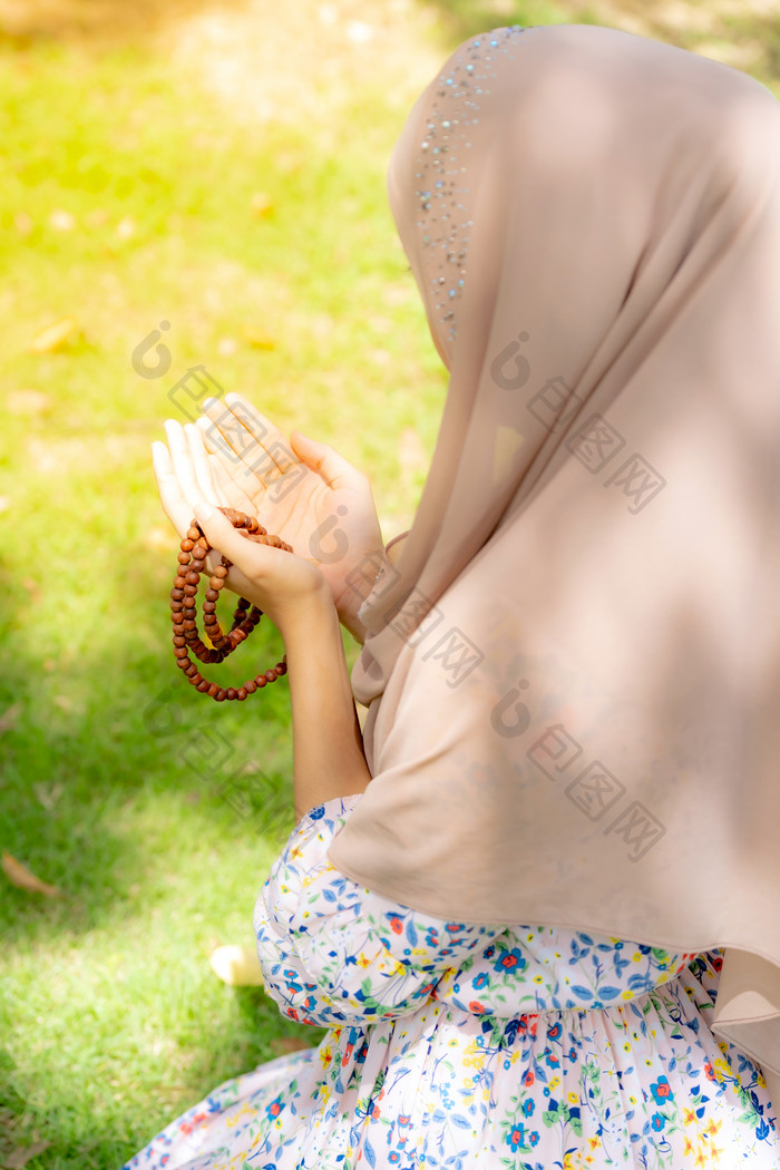 草坪上祈祷的穆斯林女孩