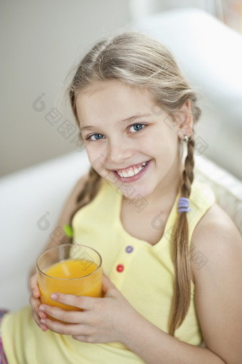 女孩<strong>端着</strong>橙汁坐在沙发