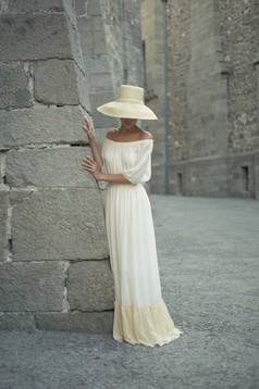 墙壁旁站着的白裙女人
