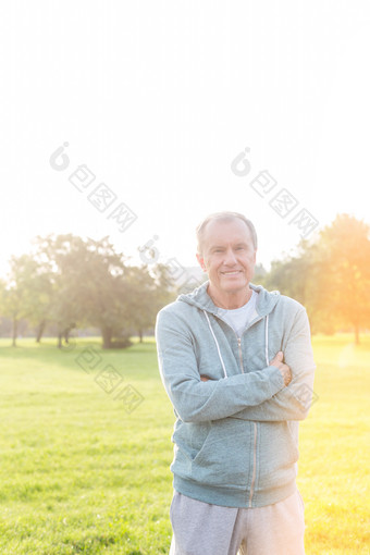 草地上抱手臂的男人