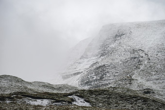 起雾的山坡雪山摄影图