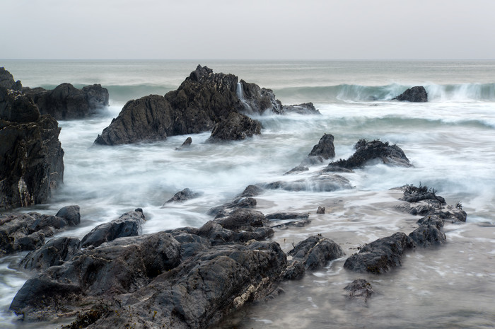 岩石海浪海滩摄影图