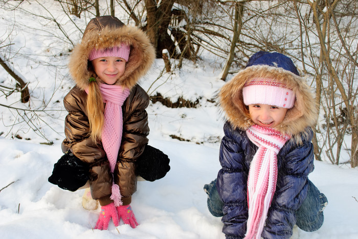 穿棉衣的儿童蹲在雪地上