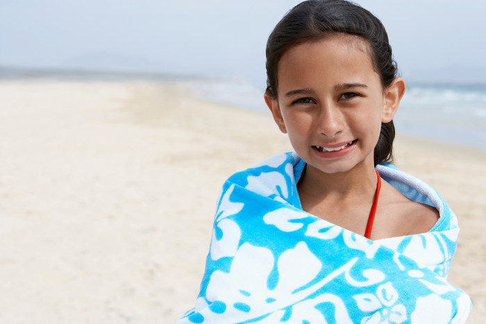 女孩沙滩上围着浴巾