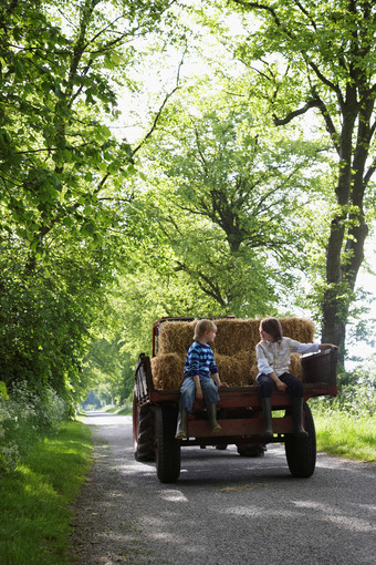 乡村小路儿童坐在拖拉机车斗