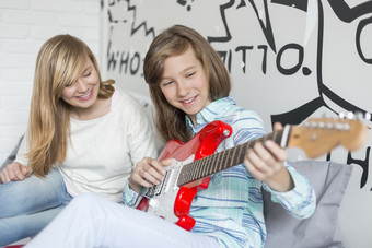 灰色调玩吉他的<strong>两个女孩</strong>摄影图