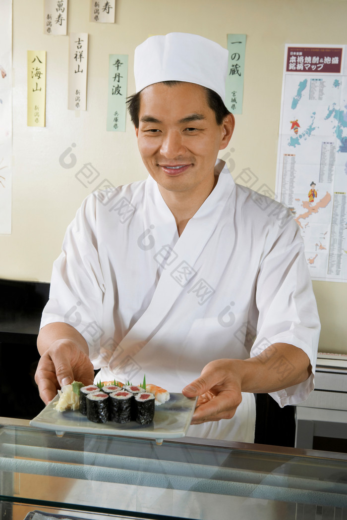 深色调做寿司的男人摄影图