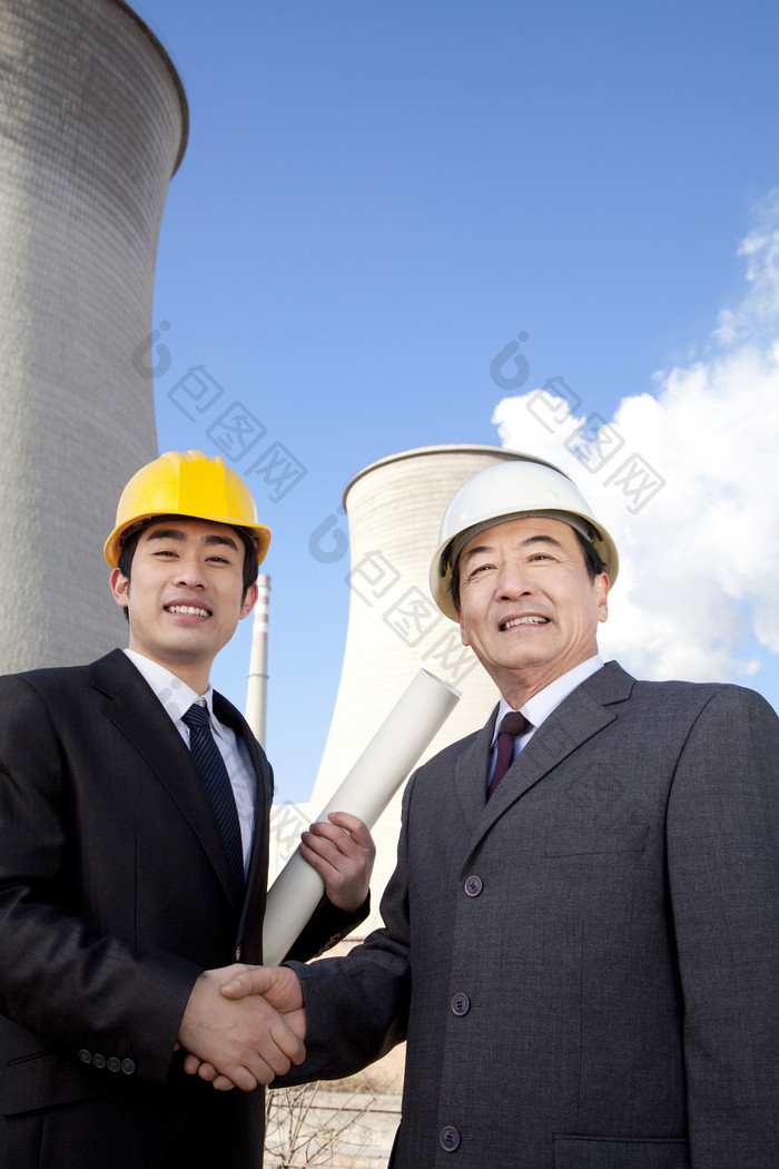 工程师站在冷却塔旁握手
