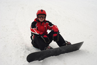 男人<strong>脚踩</strong>滑板车坐在滑雪场