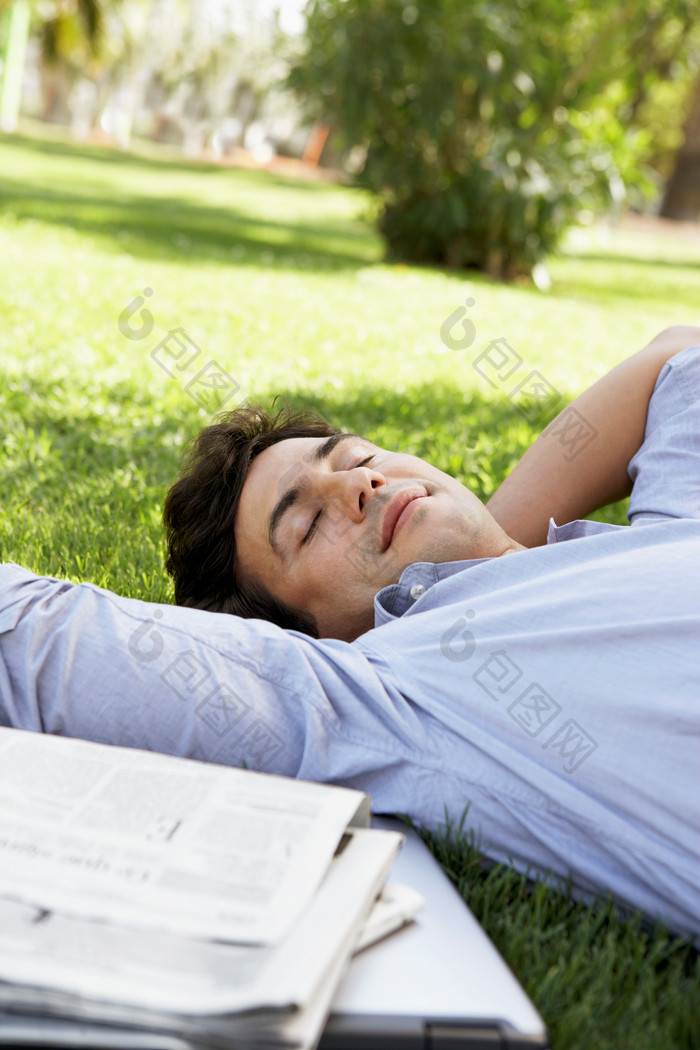 清新草地上躺着的男人摄影图