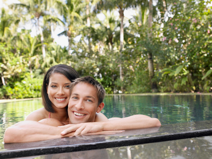 年轻夫妻趴在泳池旁图片