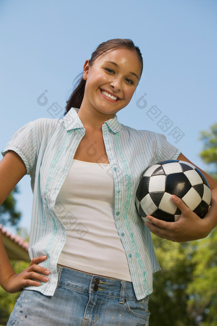 户外抱着足球的女人