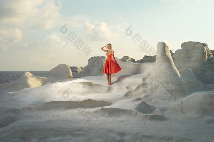 岩石旁的红裙女人