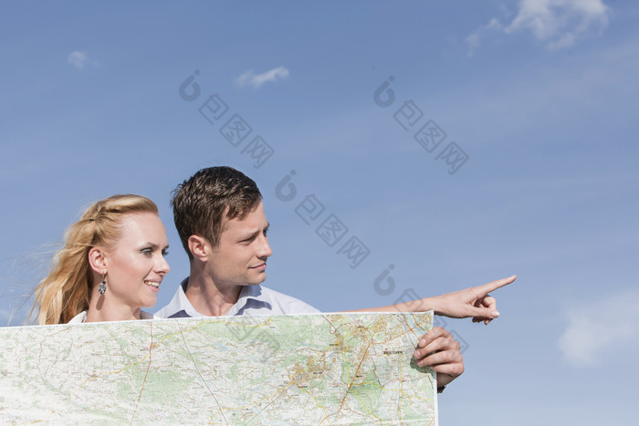 蓝色调看地图的夫妻摄影图