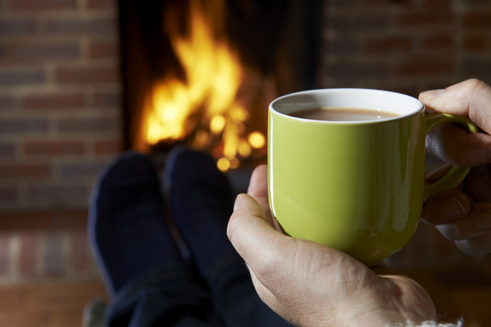 坐在壁炉旁喝咖啡取暖
