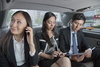 汽车上男人女人同事业务工作讨论听电话微笑