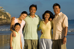 海边微笑的一家人摄影图