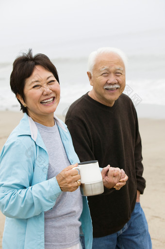 海边散步喝水的老年人