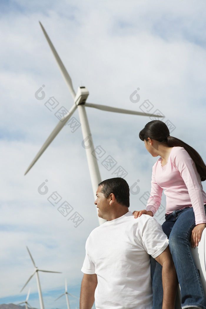 中年夫妻眺望风力涡轮机