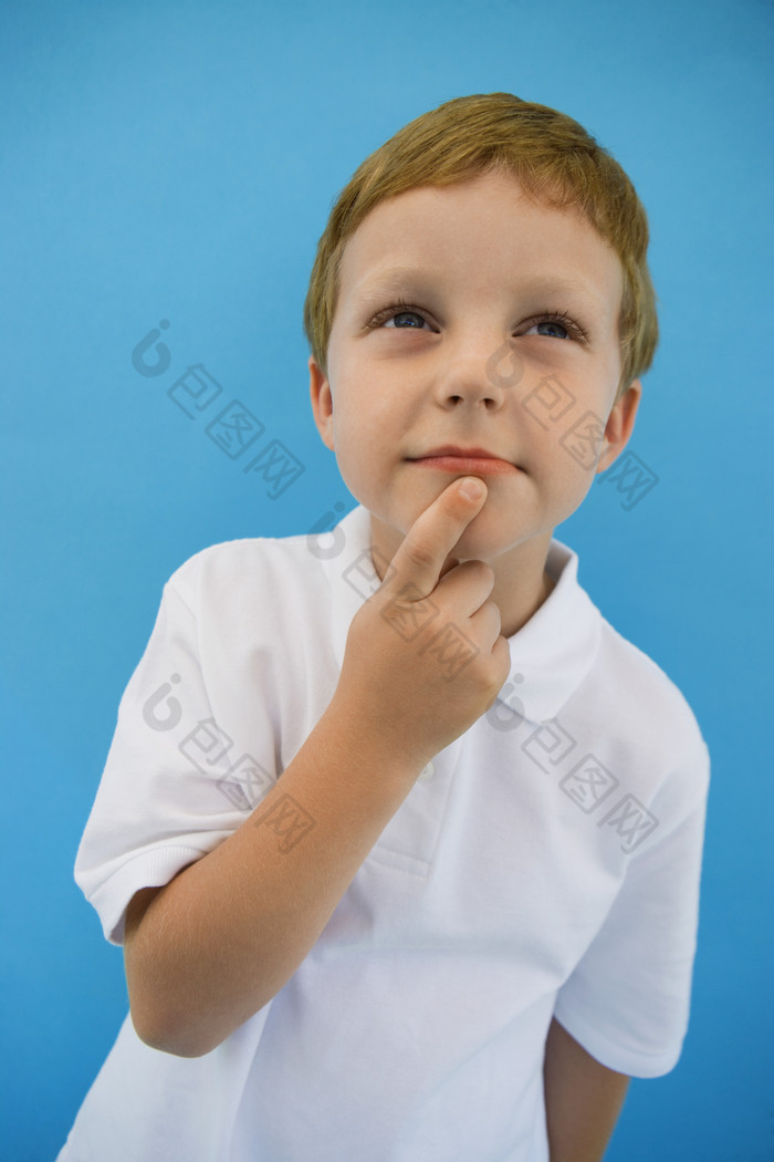 摸嘴巴的小男孩摄影图