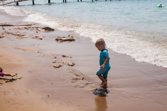 深色调海边玩耍的孩子摄影图