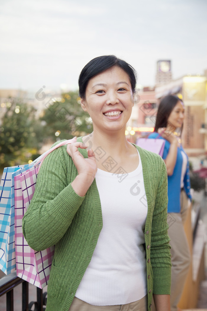 女人年轻的城市户外逛街拎着购物袋开心的