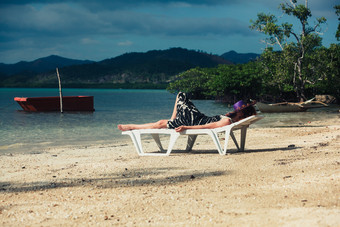 躺在沙滩椅上的人摄影图