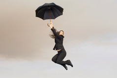 简约打伞飘起的女人摄影图