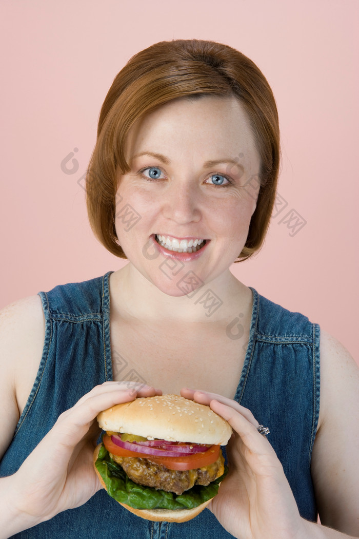 粉色调吃汉堡的女孩摄影图