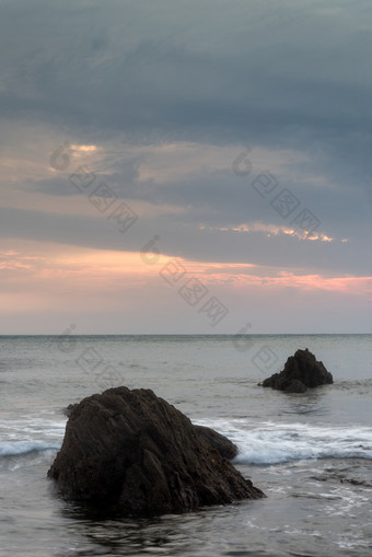 夕阳下海洋潮水中的石头