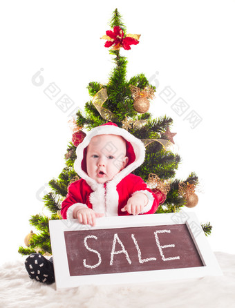 圣诞宝宝坐在圣诞树前