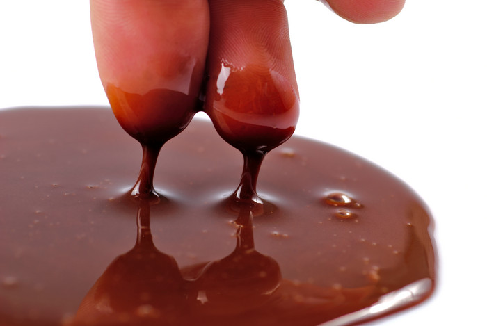 手指沾巧克力酱摄影图