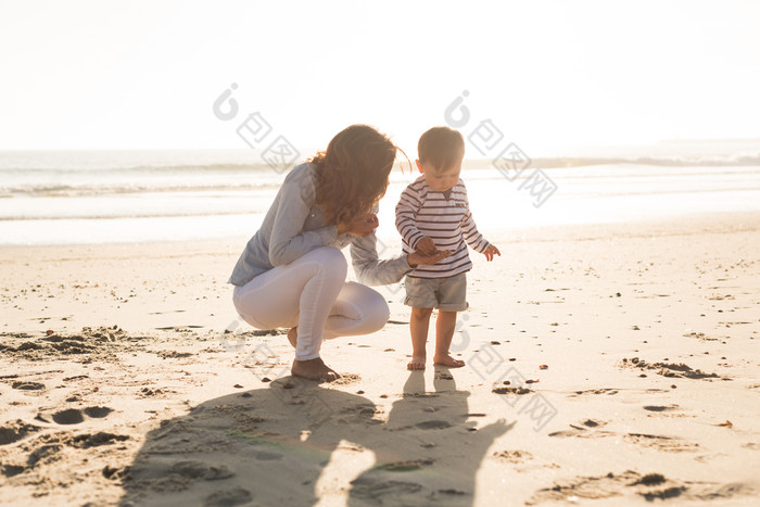 沙滩上的婴儿母亲和影子