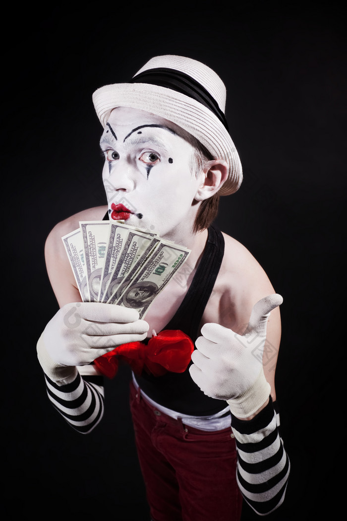 暗色调拿钱币的小丑摄影图