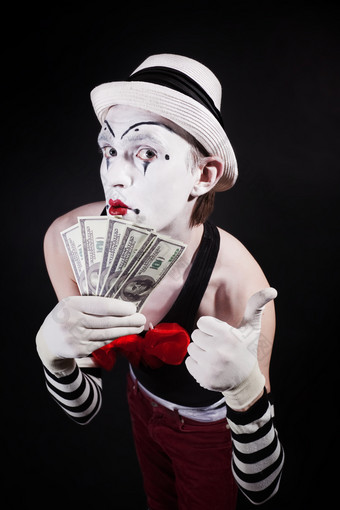 暗色调拿钱币的小丑摄影图