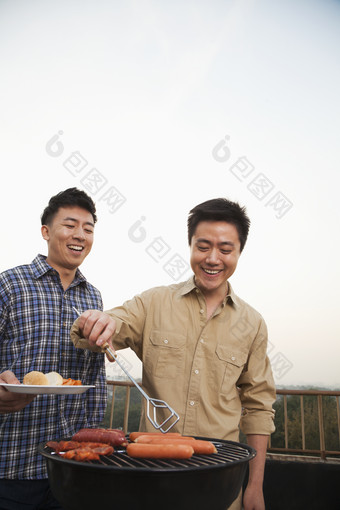 露天烧烤团建两个男人烤肉微笑食物美味