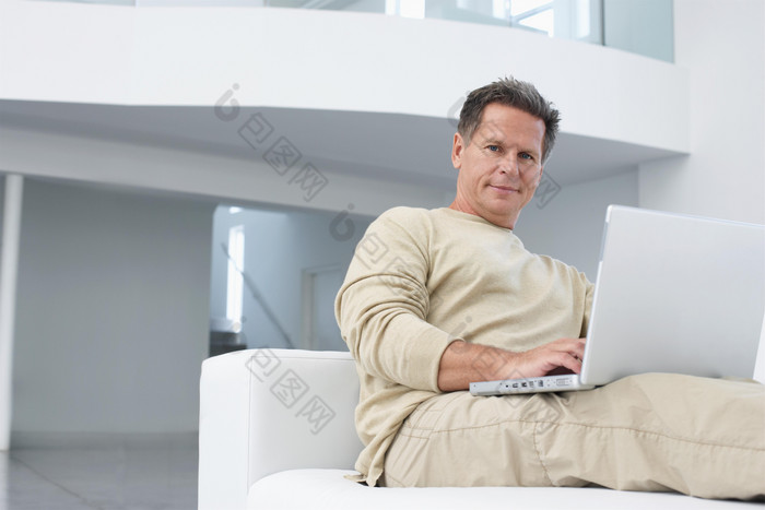 中年男人坐在沙发工作