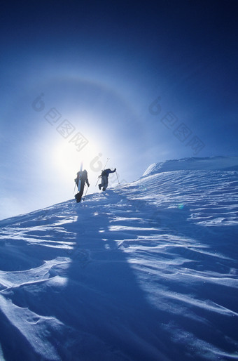 蓝色调雪山中的登山者摄影图