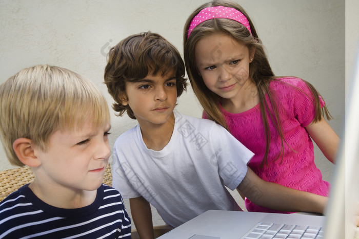三位看电脑的小孩子摄影图