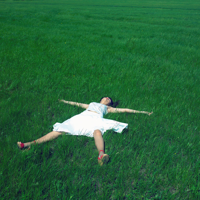 绿色调草地中的女生摄影图