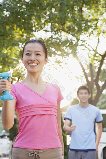 树木下<strong>锻炼身体</strong>的青年男女